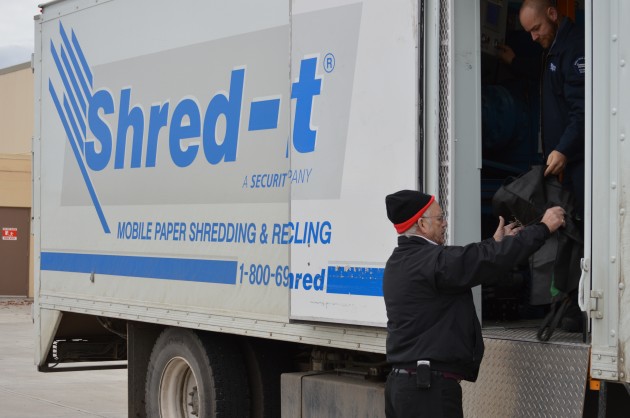 Crime stoppers president Jack Hooper hands papers for shredding. Photo 250News