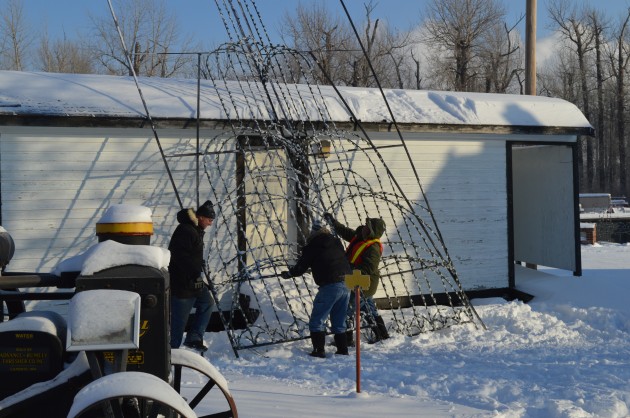 Volunteers hoist racks of lights at railway museum Saturday. Photo 250News