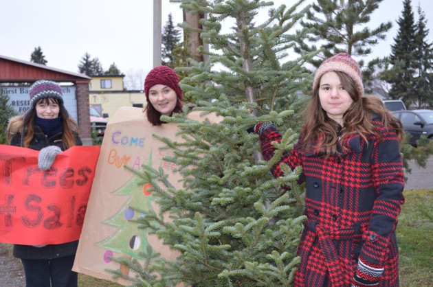 Tyra Machan (left), Jenna Bernardo and Paige Malmgren sell trees Saturday. 250News photo