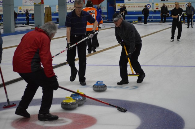 Winning skip Bill Fisher coaxes rock into place during Sunday's Kelly Cup final. Photos 250 News