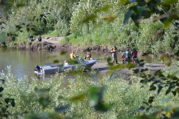 Missing boy's father and uncle watch RCMP Dive Team and SAR efforts Sunday morning. Photo 250News