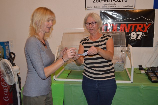 Hospice board member Sue McAllister (r) hands drawn ticket to event co-ordinator Colette Garneau. Photo 250 News