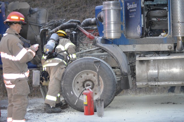 Fire officials check damage under the hood
