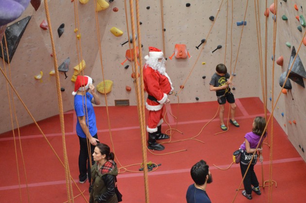 Santa looks on as climber harnesses up for climb at OVERhang Friday evening. Photos 250News