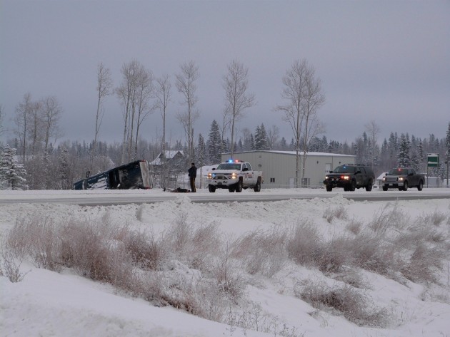 Truck lays on its side in ditch with suspect laying at side of road.