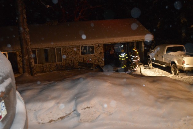 Firefighters remain on scene after extinguishing blaze at rear of house.