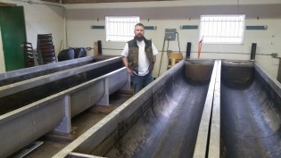 Steve Hamilton stands next to rearing tanks