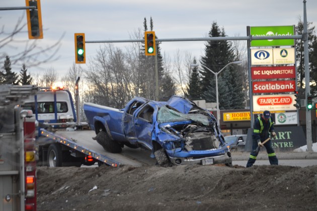 Pick-up is raised aboard flatdeck tow truck at Highway 97 and Austin Road.