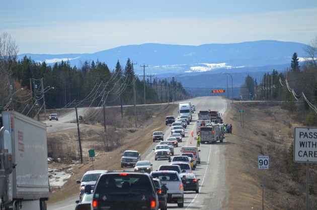 Pick-up sits off highway behind semi (left) while van occupants gather near emergency vehicles in right lane. Photos 250News