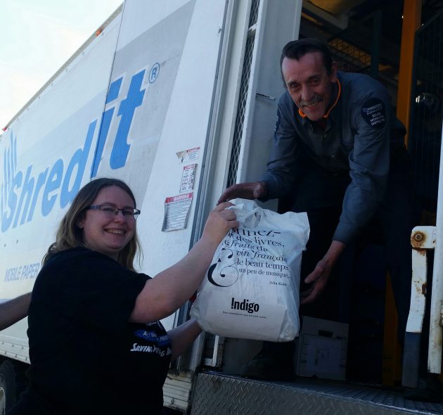 Carol Hansson hands off some documents to Randy Lewis during today's Shredding event - photo 250News