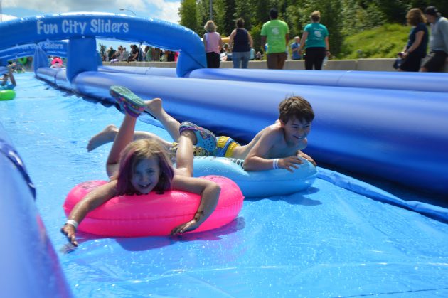 Lots of happy faces at the YMCA Slip N Slide on University Way Saturday. Photos 250 News