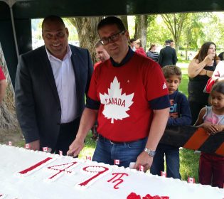 Conservative MP's Todd Doherty (left) and Bob Zimmer cut the Canada Day cake at Lheidli T'enneh Memorial Park - photo 250News