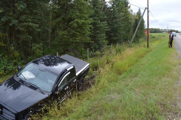 RCMP officers investigate scene of single-vehicle accident on the Hart Sunday afternoon. Photo 250News