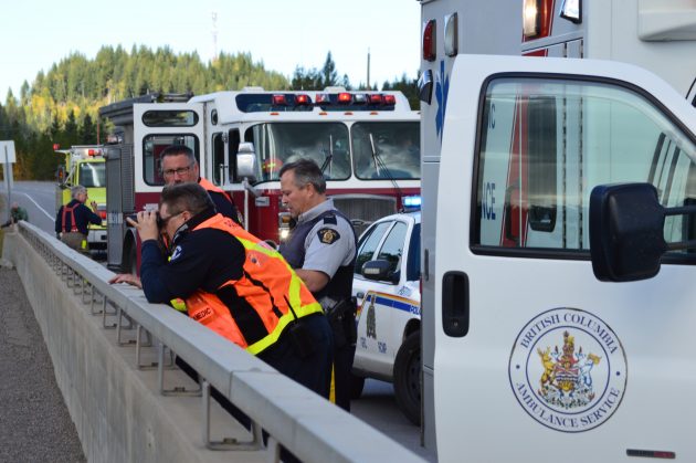 First responder scours Nechao River with binoculars from Foothills Bridge. Photos 250News