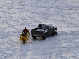 Fire Rescue personnel head back to river bank to discuss how to get disabled truck off the ice.