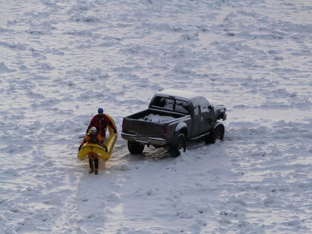 Fire Rescue personnel head back to river bank to discuss how to get disabled truck off the ice.